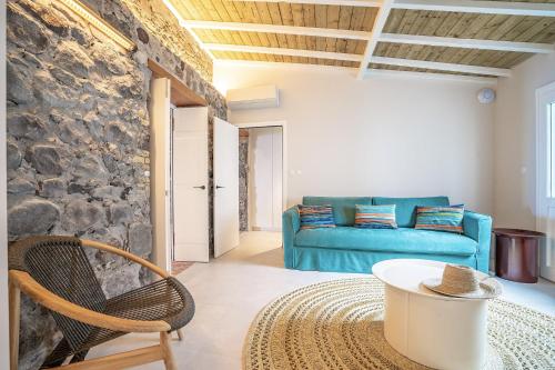 a living room with a blue couch and a table at La Petite Maison dans la mer in Saint-Pierre