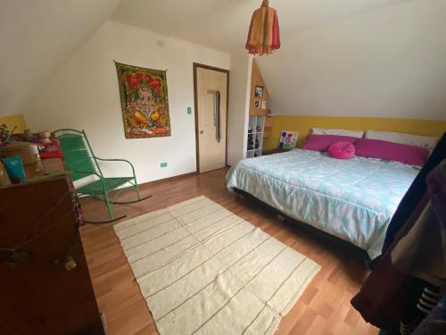 una camera con un letto, una sedia e un tappeto di Refugio urbano a Villarrica
