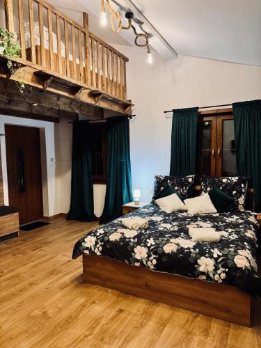 ein Schlafzimmer mit einem Bett mit einer schwarz-weißen Bettdecke in der Unterkunft Pstrągowo - domki z jacuzzi in Machowa
