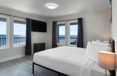 a bedroom with a bed with a view of the ocean at Ocean Escape Boardwalk Oceanfront in Myrtle Beach