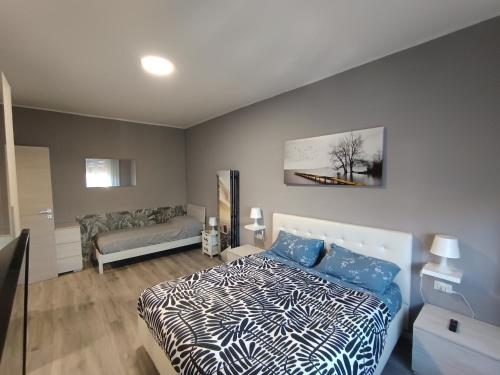 a bedroom with a bed with blue and white sheets at Work & Relax Home in Paderno Dugnano