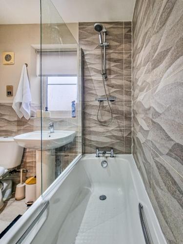 a bathroom with a tub and a sink at Truvana Haven in Coundon