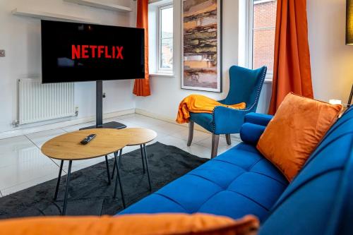 a living room with a blue couch and a tv at Truvana Haven in Coundon