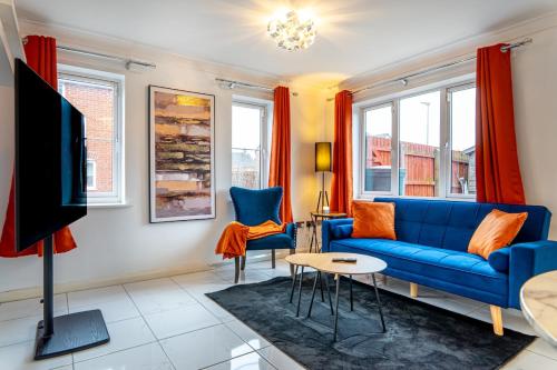 a living room with a blue couch and a tv at Truvana Haven in Coundon