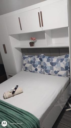ein Schlafzimmer mit einem weißen Bett und einem weißen Schrank in der Unterkunft Chalé Diamante c /AR in Volta Redonda