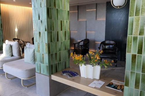 a room with a couch and a table with flowers at Seven Crown La Paz Malecon in La Paz