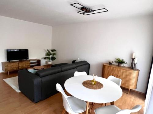 een woonkamer met een zwarte bank en een tafel bij City Appartment Neuss in Neuss