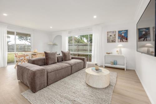 a living room with a couch and a table at 5 min walk to beach, 5 min drive to shops in Capel Sound