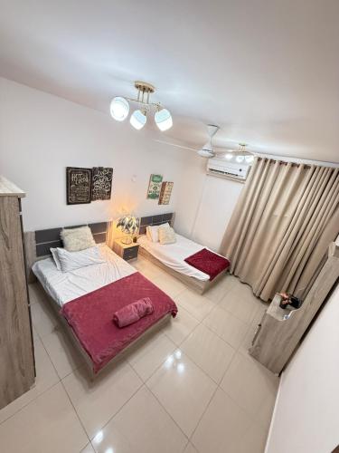 a room with two beds in a room at Opera67 Spacious & Central in Ghubrah