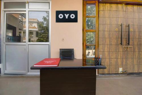 a desk with a red book in front of a building at Hotel O Shubham Paradise in Hasanganj