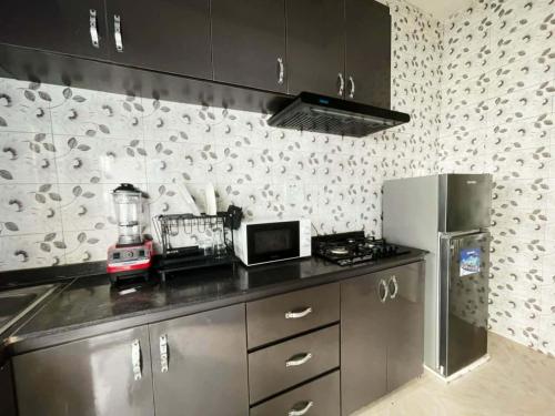 a kitchen with a counter top and a refrigerator at Phienu Apartment & Suite in Warri