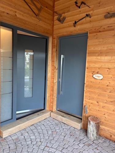 two large glass doors on a wooden wall at Schneekopfblick in Oberhof