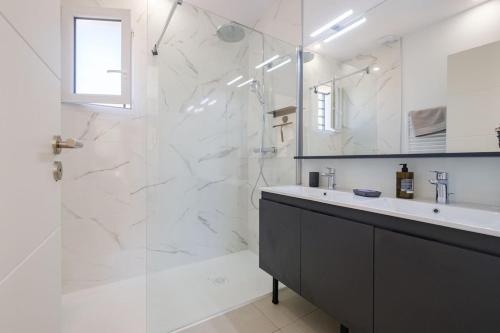 ein weißes Badezimmer mit Dusche und Waschbecken in der Unterkunft Luxurious new villa pool golf St Tropez in Sainte-Maxime