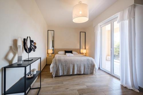 ein Schlafzimmer mit einem Bett und einem großen Fenster in der Unterkunft Luxurious new villa pool golf St Tropez in Sainte-Maxime