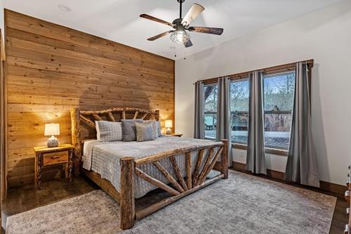 een slaapkamer met een houten wand en een bed met een plafondventilator bij Fireside Living in Galloway