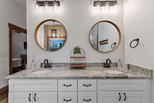 een badkamer met twee wastafels en twee spiegels bij Fireside Living in Galloway