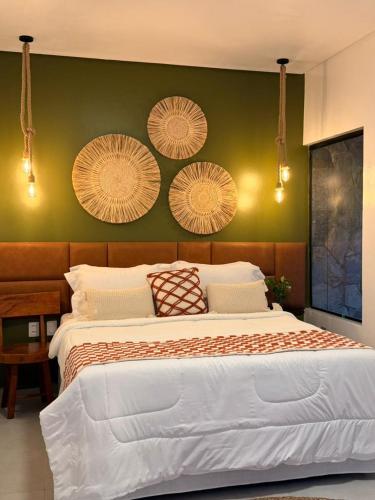 a bedroom with a large bed with a green wall at Pousada Alkamar in Maragogi