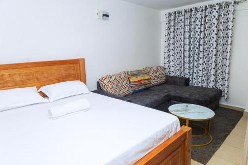 une chambre avec un lit et un canapé dans l'établissement Kasarani Studio Apartment, à Nairobi