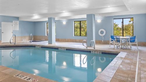 a swimming pool with blue walls and a table and chairs at Holiday Inn Express Hotel & Suites Manchester - Airport by IHG in Manchester