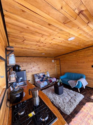 een kamer met een fornuis en een bank in een hut bij Casa Jaguar Neusa in Tausa Viejo