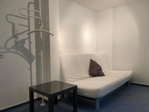 een witte bank en een tafel in een kamer bij Monteur- oder Wandererwohnung im Hildesheimer Wald in Diekholzen