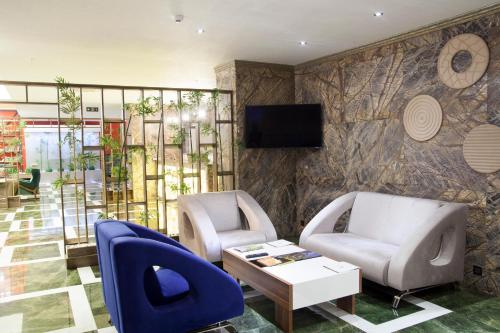 - un hall avec 2 chaises, une table et une télévision dans l'établissement Neba Royal Hotel, à Samsun