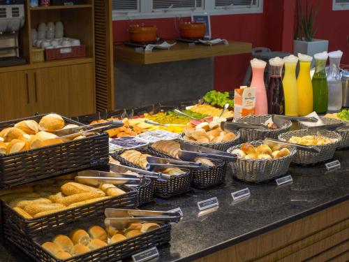 a buffet with many baskets of food on a counter at ibis Araçatuba in Araçatuba