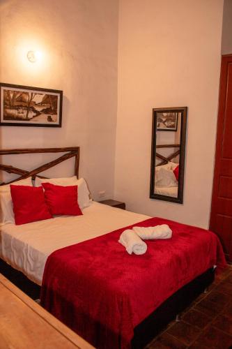 a bedroom with a large bed with red pillows at Kazasha Terra in Barichara