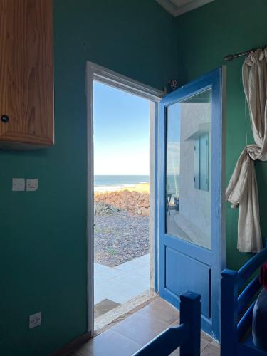 a door to a room with a view of the ocean at Beachfront villa sidi ouarzeg in Sidi Ouarsik