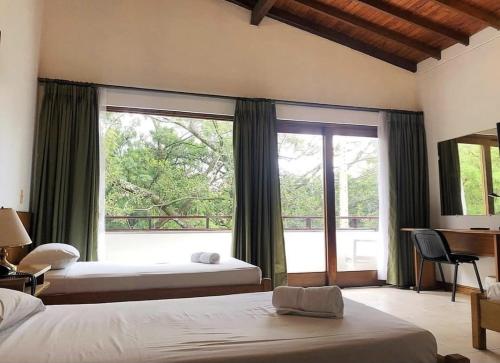 una camera da letto con due letti e una grande finestra di Hotel Balcones De Malibu a Medellín