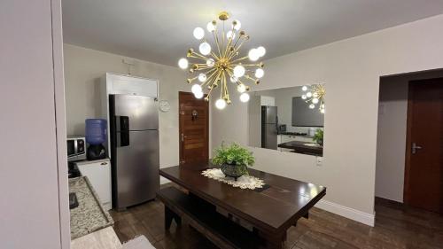 een keuken met een eettafel en een kroonluchter bij Jardim dos Ipês in Araranguá