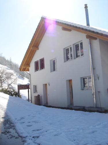 a white house with snow on the side of it at Ferienwohnung Suter in Seewen