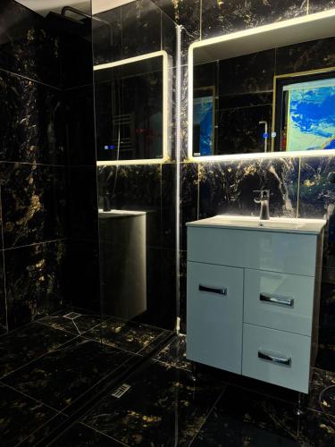 ein Badezimmer mit einem weißen Waschbecken und einem Spiegel in der Unterkunft Casa Daiana in Aninoasa