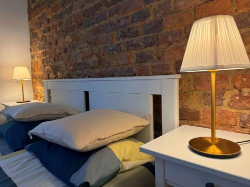 a bedroom with two beds and a table with a lamp at Apartament na Starówce in Wałbrzych