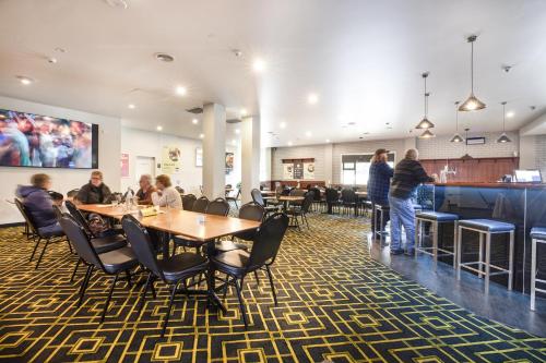 a group of people standing in a restaurant with tables and chairs at Nightcap at Burnie Townhouse in Burnie