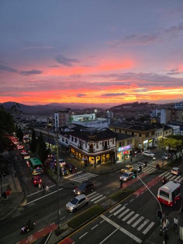 a city with cars parked on a street at sunset at Apartaestudio con vista a AV Santander Manizales in Manizales