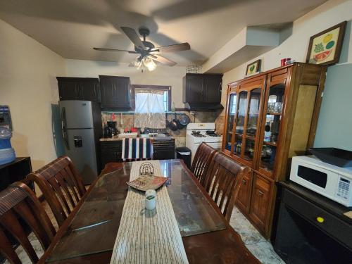 una cucina con tavolo, sedie e ventilatore a soffitto di Casa Villafontana a Mexicali