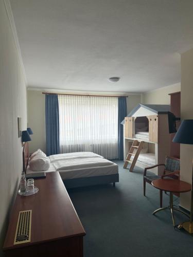 ein Hotelzimmer mit Bett und Schreibtisch in der Unterkunft Hotel Krohwinkel in Hittfeld