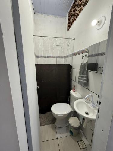 a small bathroom with a toilet and a sink at Suíte Brisa Mar Saquarema in Saquarema