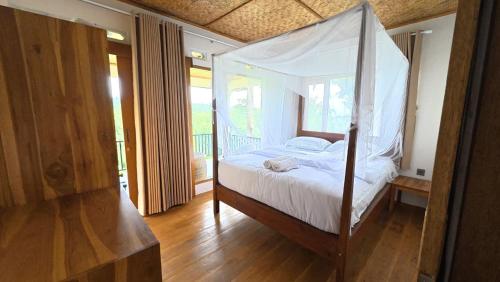 een slaapkamer met een hemelbed bij D'Sawah Tetebatu Villas in Tetebatu