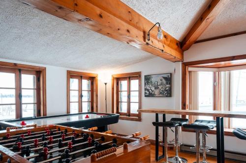 a billiard room with a pool table and some windows at Le Repere du Lac - Lake View Access & Spa in Venise-en-Québec