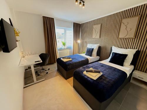 a hotel room with two beds and a desk at Business Apartment City 5 Betten & Parkplatz in Lüdenscheid