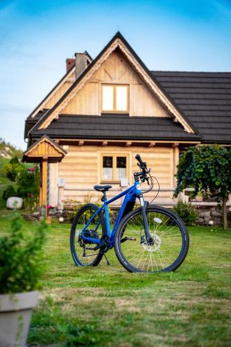 a blue bike parked in front of a house at Pocztówka z Mizernej, drewniane domki, widok na Tatry, blisko Velo Czorsztyn, Jezioro Czorsztyńskie, rowery, spokojna okolica in Kluszkowce