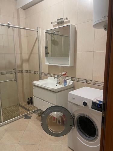 a bathroom with a washing machine and a sink at Ahmet Pasha apartments ne qender te Pejes me nji dhom te fjetjes e sallon qe i ka dy shtreter in Peje