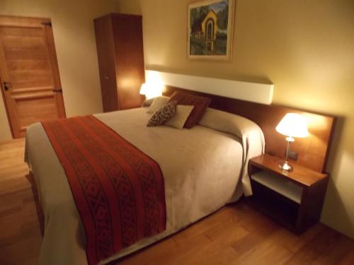 a bedroom with a large bed with two lamps on it at Noha Casa de Campo in Colón