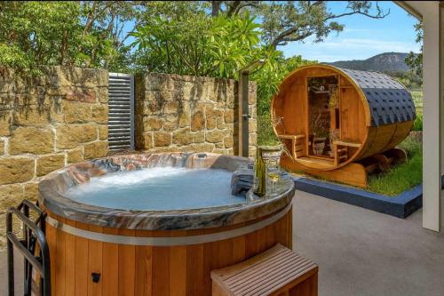 a large wooden hot tub in a yard with a iguana at Brokenback Homestead in Pokolbin