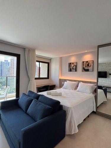 a bedroom with a large bed and a blue couch at Exclusividade e Conforto a 500m da Beira-Mar in Fortaleza