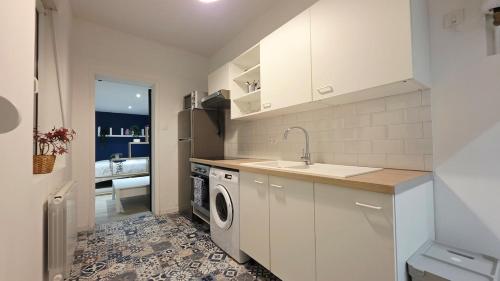 une cuisine avec un évier et une machine à laver dans l'établissement Charmissime, à Dunkerque