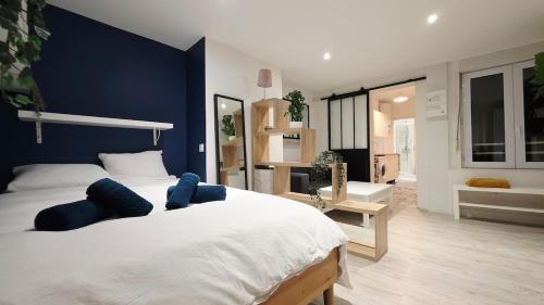 une chambre avec un grand lit blanc avec des murs bleus dans l'établissement Charmissime, à Dunkerque