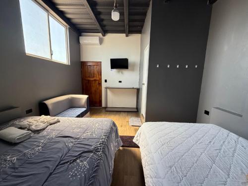 a bedroom with a bed and a television in it at La Casa D Juan in Puerto Baquerizo Moreno